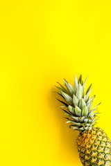 Fototapeta na wymiar Pineapple - whole fruit - on bright yellow background top-down copy space
