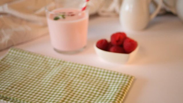 Woman hand take a glass of natural homemade yogurt with fresh raspberry. Breakfast concept