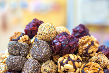 Close-up of assorted nuts and fruit cakes in the form of balls. Sweet wholesome dessert on a blurry background.