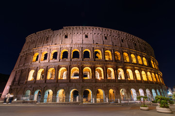 Naklejka premium Colosseum at night, an oval amphitheatre and the most popular tourist attraction in Rome, Italy