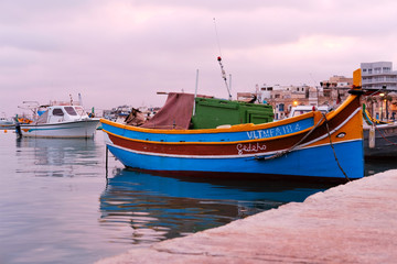 Naklejka na ściany i meble traditional fishing boats of Marsaxlokk, Malta at sunset