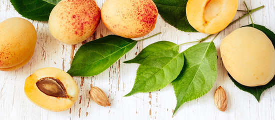 Ripe beautiful apricots on white wooden table. White natural banner with tasty fruits