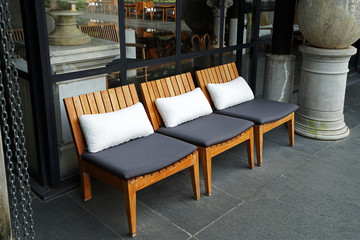 Row of wooden chair with cushion pillows