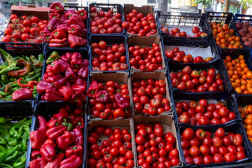 Fresh green and red paprika, tomatoes, oranges, peaches on a vegetable counter at the street shop in Spain. Buy organic food on the local market from rural farms for best cooking