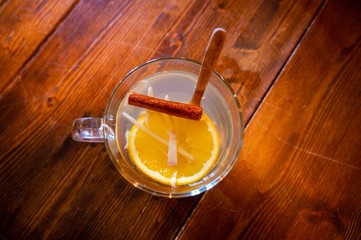 Vista superior de una taza de te con naranja en una mesa de madera