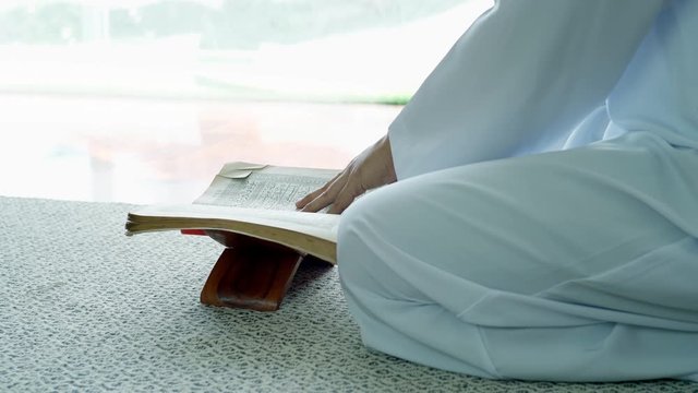 Portrait of Asian Muslim man reciting surah al-Fatiha passage of the Qur'an, in a daily prayer at home in a single act of sujud called a sajdah or prostration