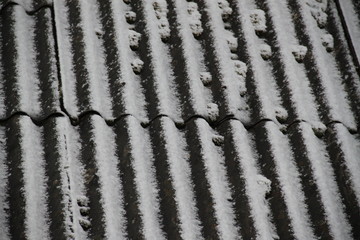 Snow flakes fall on timbered house