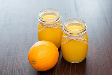 Orange juice in jars and whole fruit rustic style