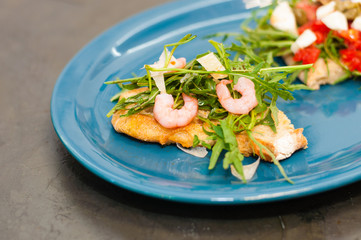 Bruschetta with shrimp, arugula, tomatoes, cheese and sauce, close-up, high Italian cuisine