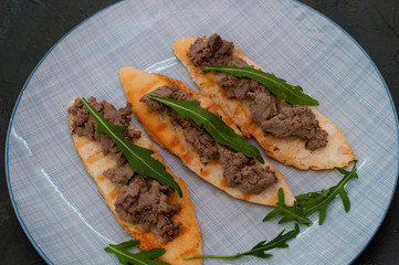 Croutons with paste and arugula. Festive appetizer, New Year's Italian dish. The view from top and there is room for text