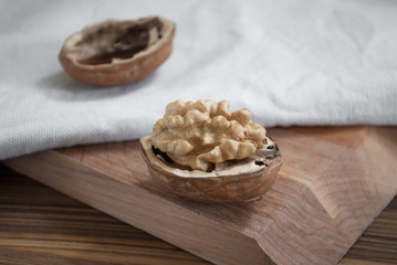 several walnuts with an open kernel lies on a wooden board
