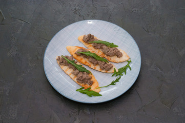 Croutons with paste and arugula. Festive snack New Year Italian dish. Top view, copy space.