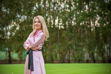 Spring natural romantic outfit, lady in pink coat at park