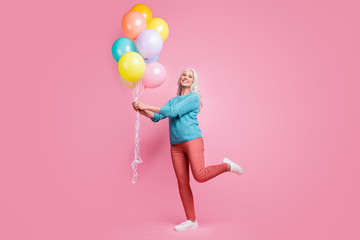 Full length photo of positive cheerful lovely pretty grandmother hold air helium baloons enjoy festive family occasion wear sweater pullover sneakers isolated pastel color background