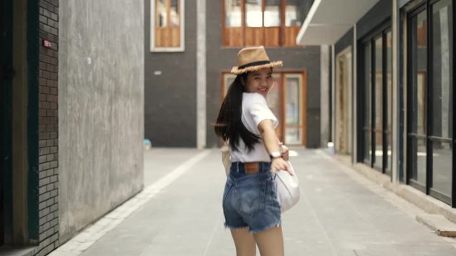 Attractive beautiful asian female calling you to come along with her enjoying having fun vacation weekend travel in the old town. Happy holiday travel lifestyle teenager.