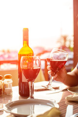romantic dinner at sunset, red wine on the table