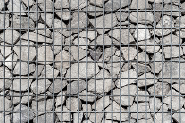 Stones wall behind the metal grid.