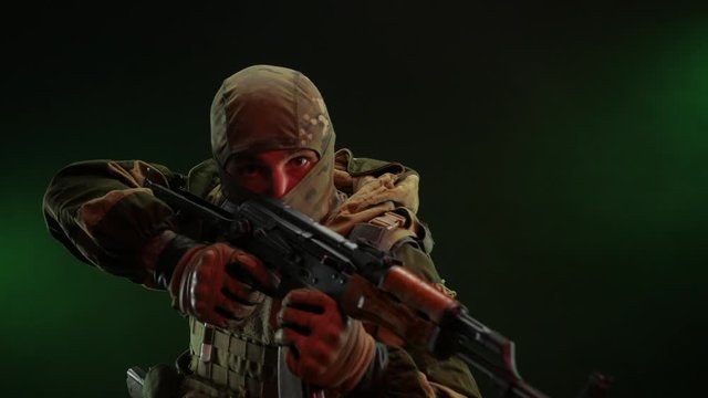 a rebel commando soldier in military clothing with a Kalashnikov rifle on a dark background takes aim