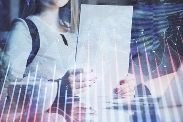 Double exposure of hands making notes with forex chart huds. Stock market concept.