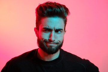 Beautiful caucasian young man portrait isolated on multicolored neon light backgroud. Young, smiling, surprised, screaming. Human emotions, facial expression concept. Trendy colors.Advertising concept