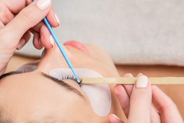 Obraz na płótnie Canvas Beautiful woman receiving eyelash extension procedure, close up.