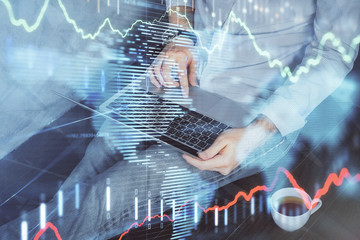 Forex graph with businessman working on computer in office on background. Concept of analysis. Double exposure.