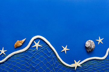Top view of rope, fihishing net and sea objects on the blue background.Free space.Concept of summer...