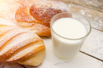 glass of milk, loaf, on a wooden background with flour. Balanced diet, protein and carbohydrates, cereals