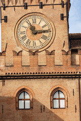 Fototapeta na wymiar Torre degli Accursi and Palazzo d'Accursio. Closeup of the clock tower and Town hall in downtown of Bologna (XIII century), Piazza Maggiore, Emilia-Romagna, Italy, Europe