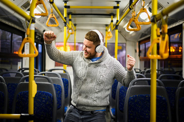 Man with headphones dancing alone in the bus