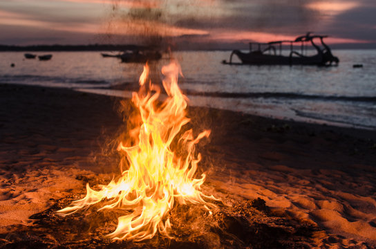 Detalle de una hoguera en la playa durante el atardecer en Bali