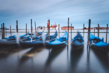 Gondolas floating in the Grand Canal in front of San Giorgio Maggiore church in background. Long exposure picture