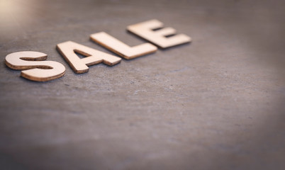 Text "Sale" written with wooden letters on slate background with free space for text
