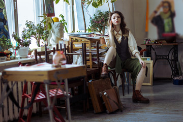 Beautiful girl artist sits in a workshop.