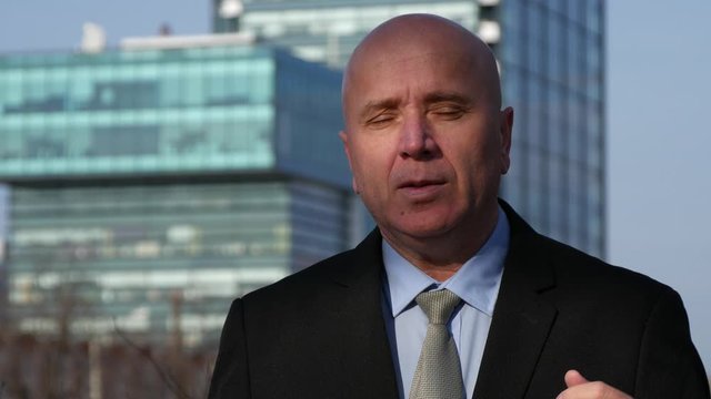 Businessman Giving an Interview Talking and Gesturing on the Street About Financial Opportunities 
