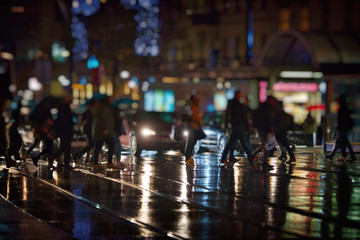 pedestrians walking on rainy night in the city
