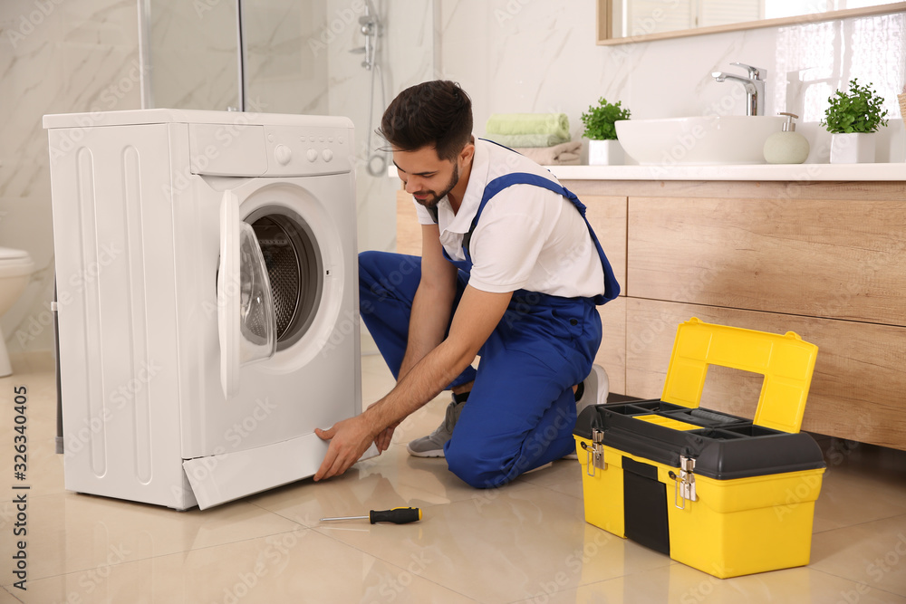 Canvas Prints professional plumber repairing washing machine in bathroom