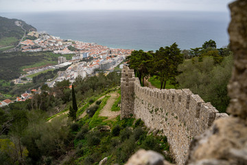 Beautiful aerial view of Sesimbra, Portugal - as seen from the castle on the hill, with defensive castle walls framing the photo