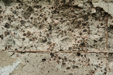 Abstract background. Old rough texture, gray concrete wall with rusty fittings, small expanded clay and holes from fallen stones. Structure, texture, background.