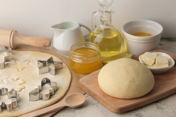 making delicious cookies. Cookie cutters. Dough for baking. Ingredients for the dough, eggs, flour, butter, sugar on a light background.