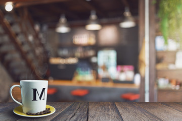 Wood table top with blur in coffee shop. with white coffee cup, vintage color tone.