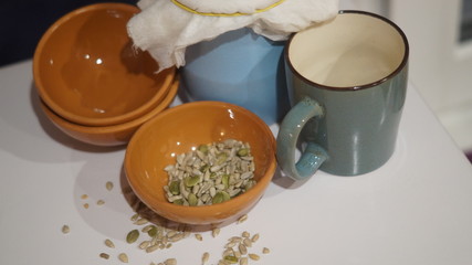 a blue earthenware jug and mug, small brown saucers with grits on a dark background
