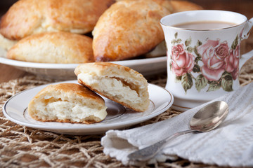 Cottage cheese pies in a plate and cup with coffee