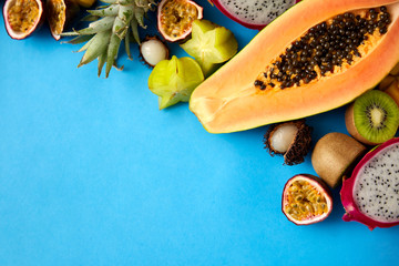 food, summer and healthy eating concept - different exotic fruits on blue background