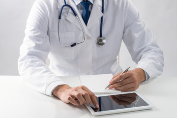 Close up of doctor hands using tablet computer