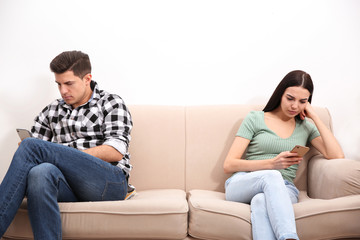 Couple addicted to smartphones ignoring each other at home. Relationship problems