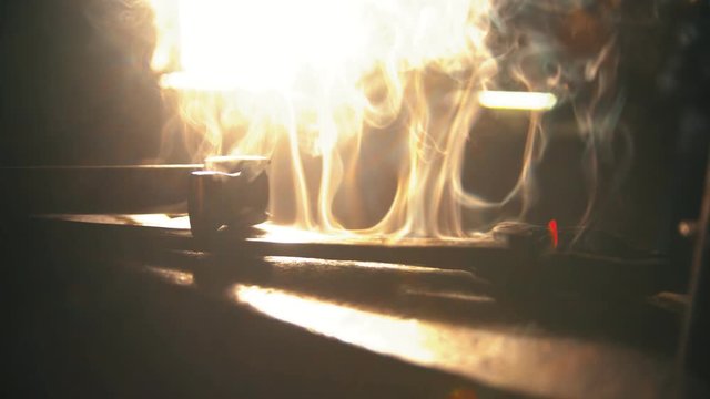 A blacksmith instrument lying on the anvil with steam comes off it