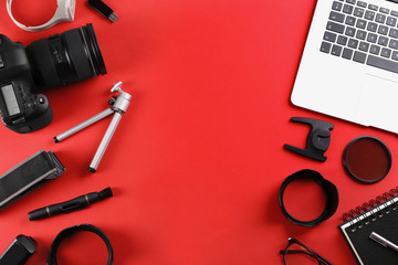 Flat lay composition with camera and video production equipment on red background. Space for text