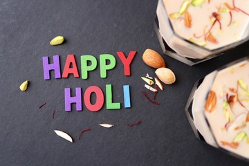 Indian Holi festival food or drink Thandai. It is an Indian cold drink prepared with a mixture of Milk, Dry fruits, sugar & spices. Garnished with Almonds, Pistachio & saffron. Happy Holi. copy space.
