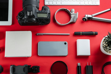 Flat lay composition with camera and video production equipment on red background